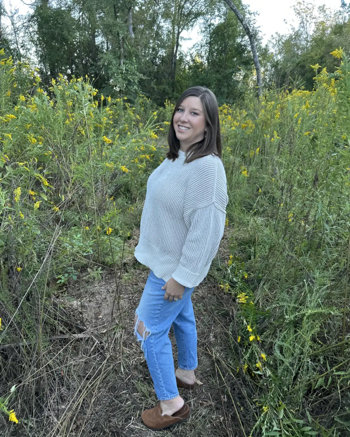Heather smiling on a path among tall yellow goldenrod